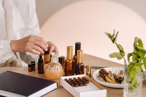 Primo piano delle mani di una donna che applica l'olio essenziale sulla parte interna del polso