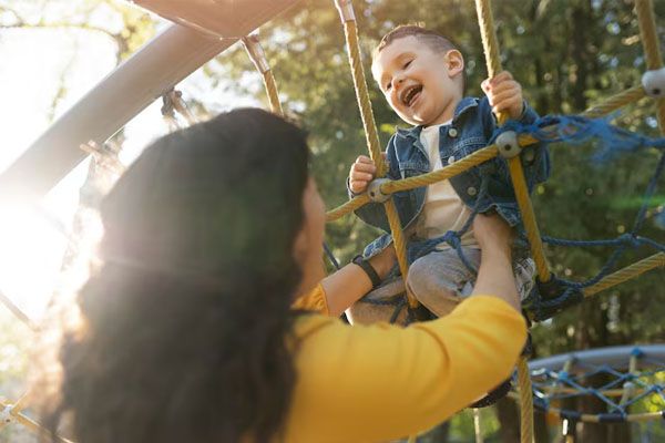 madre che gioca con un bambino felice nel parco