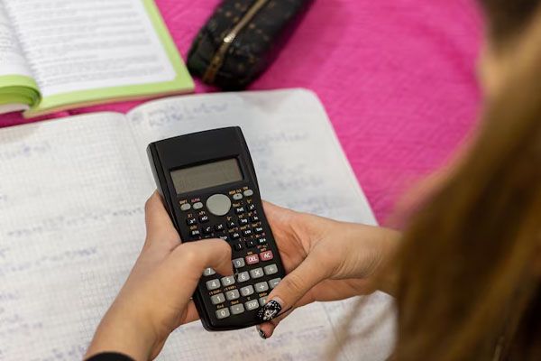 Primo piano delle mani di un adolescente che contano su una calcolatrice scientifica