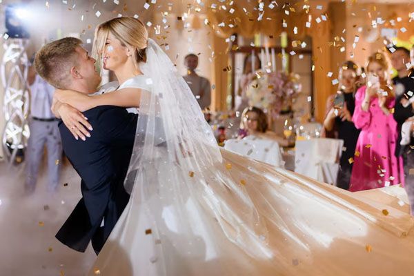 couple waving while dancing with confetti