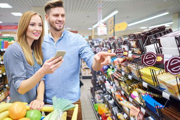 coppia che guarda i prodotti nel corridoio di un supermercato