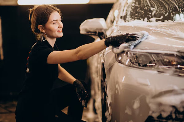 Donna che lava un'auto a mano