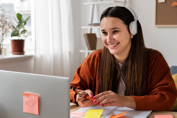 Giovane donna seduta alla scrivania davanti al computer portatile