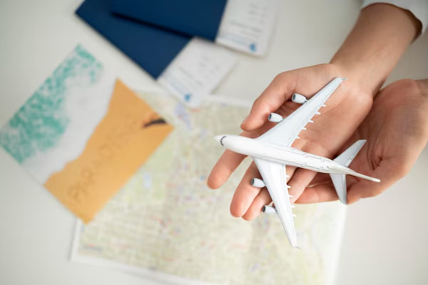 Primo piano di una mano che regge un modellino in scala di un aereo di linea