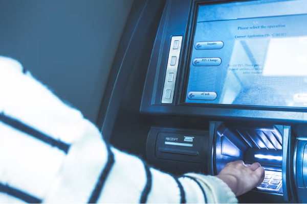 La mano di una persona che usa un bancomat