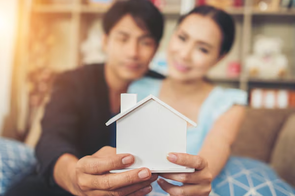 coppie che tengono insieme una casa in miniatura