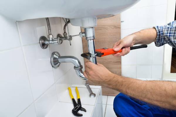 Primo piano di mani che lavorano su un tubo